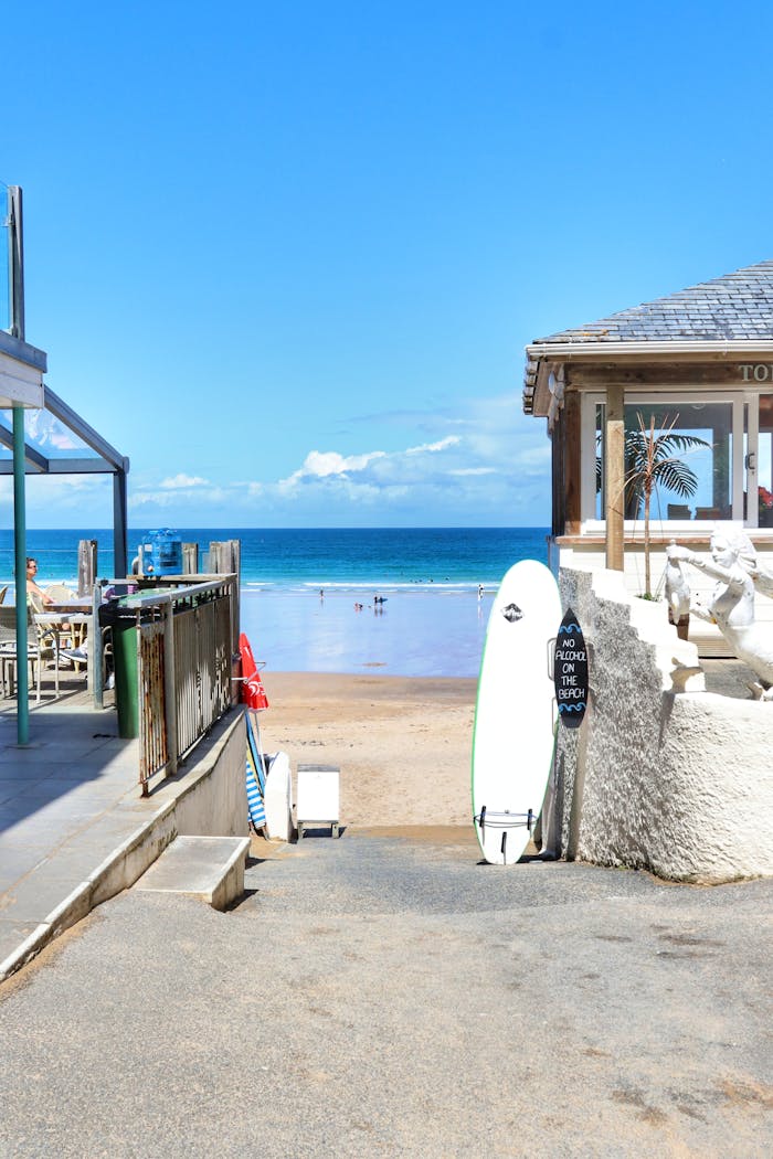Inviting view of a beach path with surfboards in Newquay, perfect for a summer getaway.